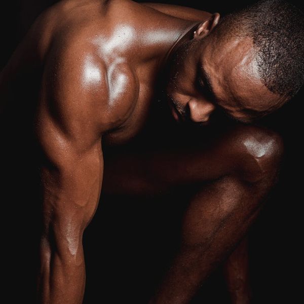 A man stretching his leg muscles in a bright, clean training area.